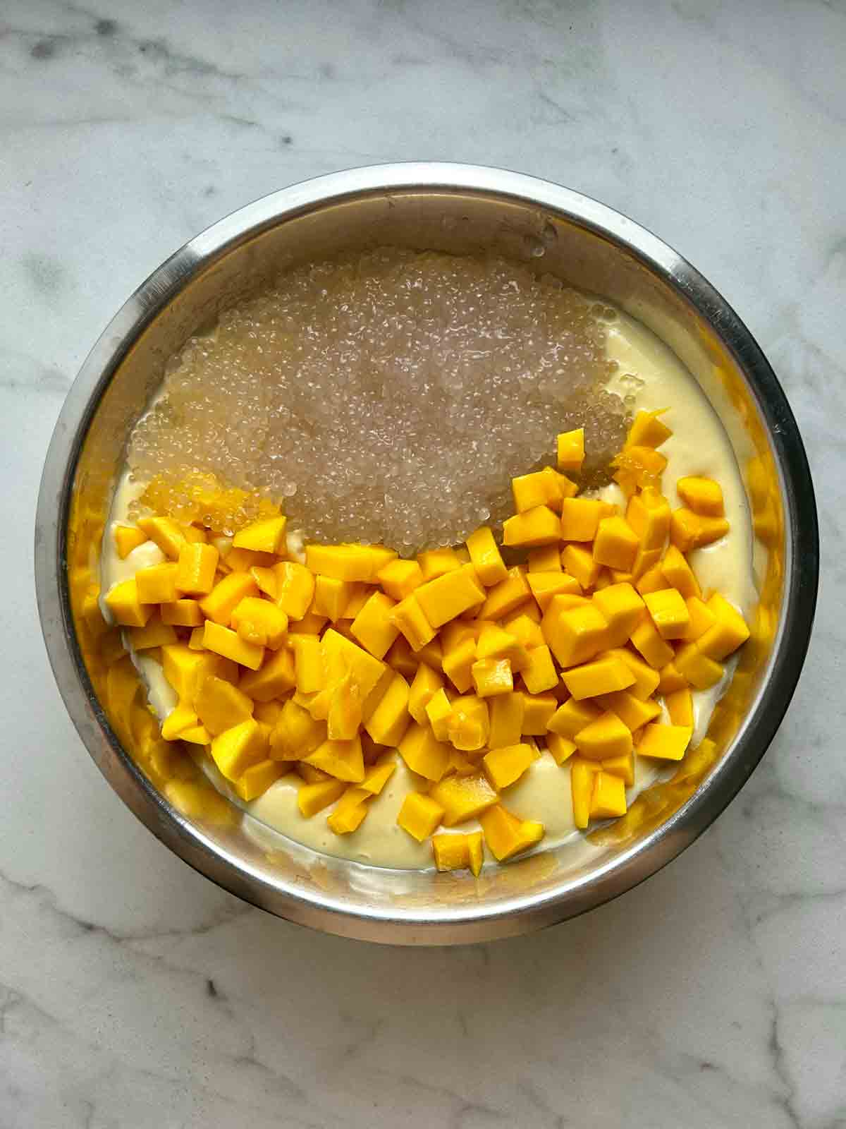 tapioca and chopped mango added to bowl of mango puree.