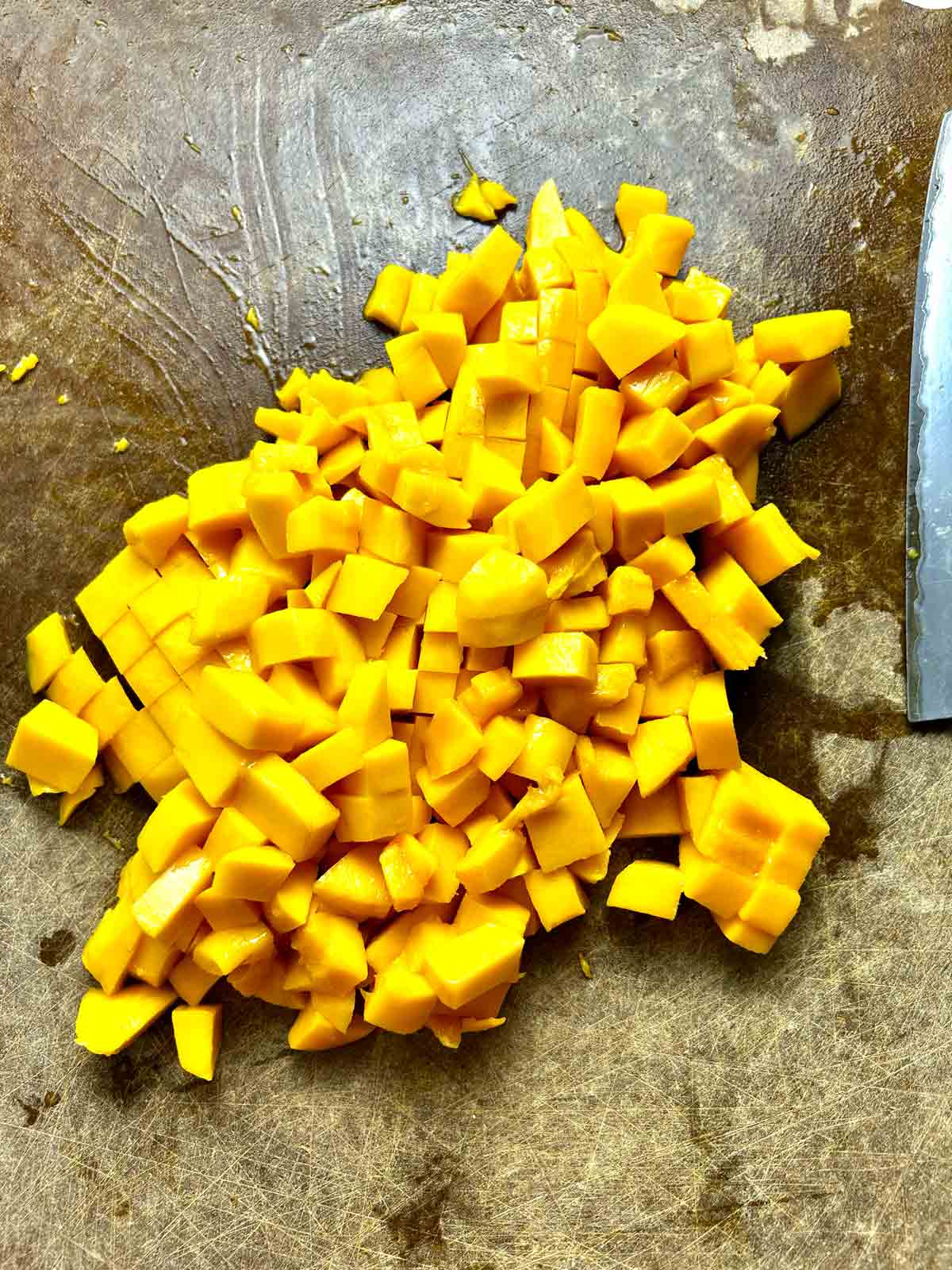 mango chopped into small pieces on cutting board.