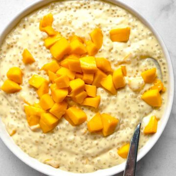close up of mango sago in bowl with spoon in it.