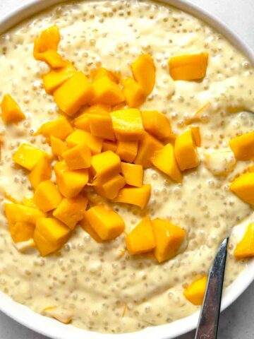 close up of mango sago in bowl with spoon in it.