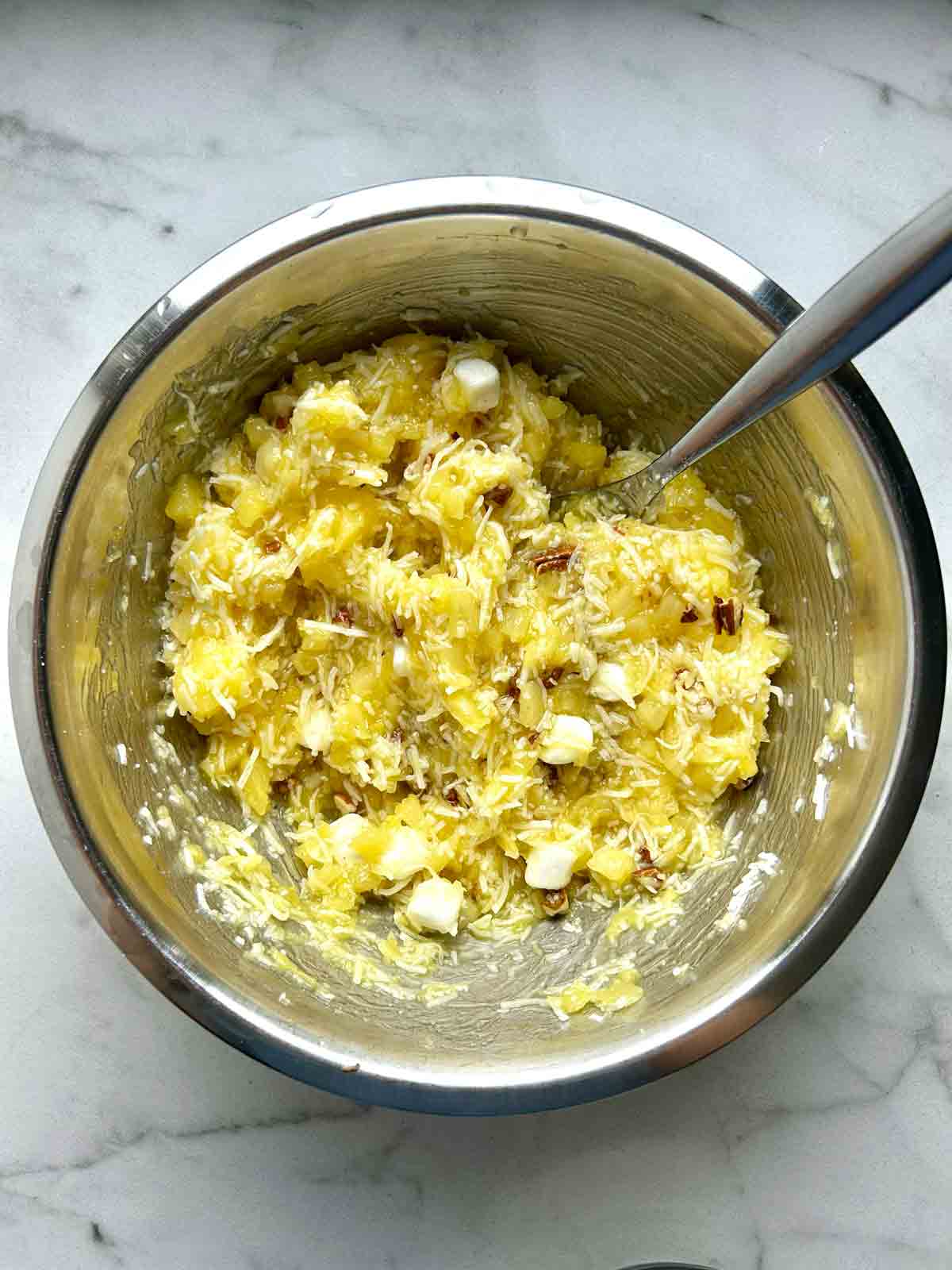 walnuts, marshmallows, and coconut flakes stirred into pineapple mixture.