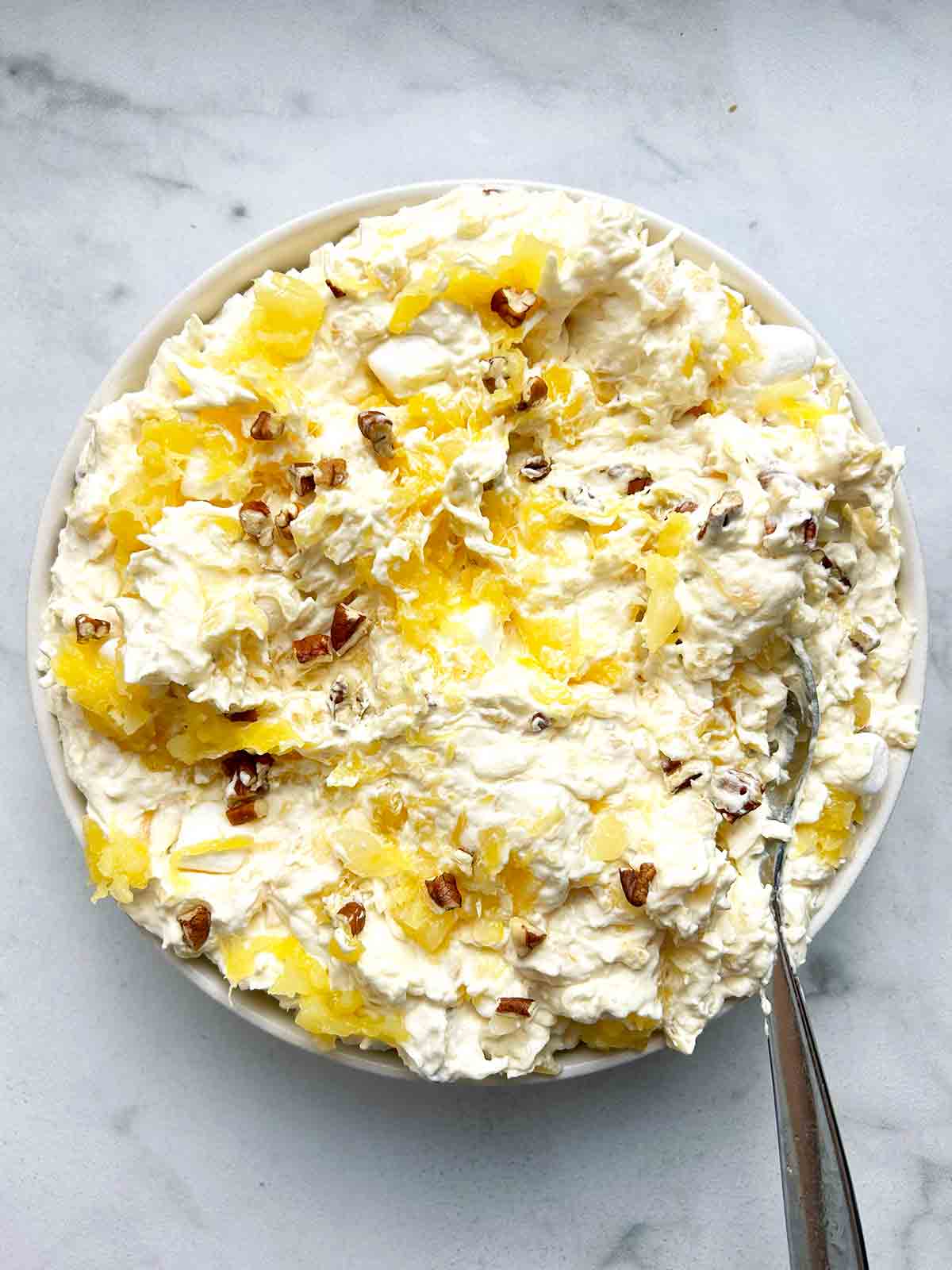 bowl of pina colada fluff with spoon in it.