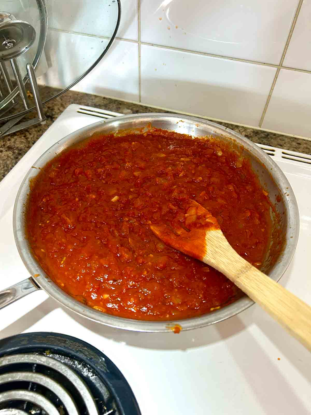 marinara sauce added to skillet of onions and garlic.