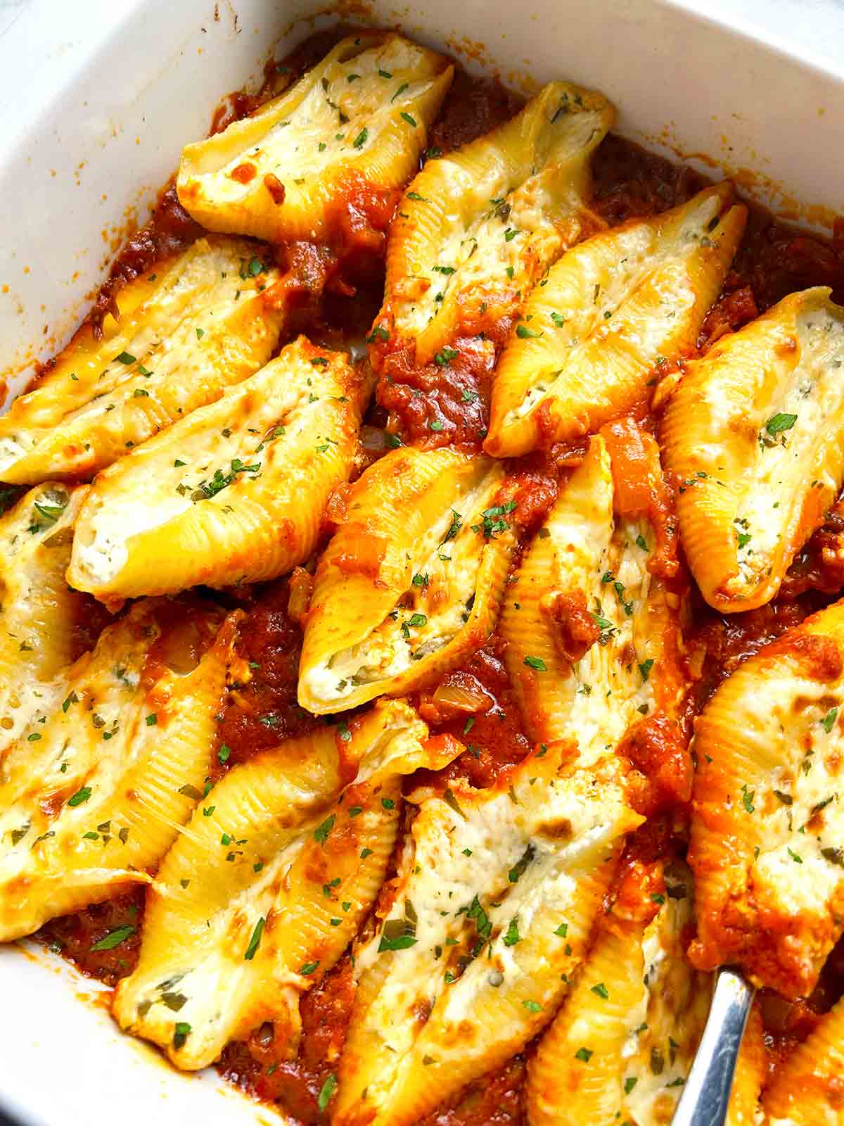 close up of stuffed shells in baking dish.