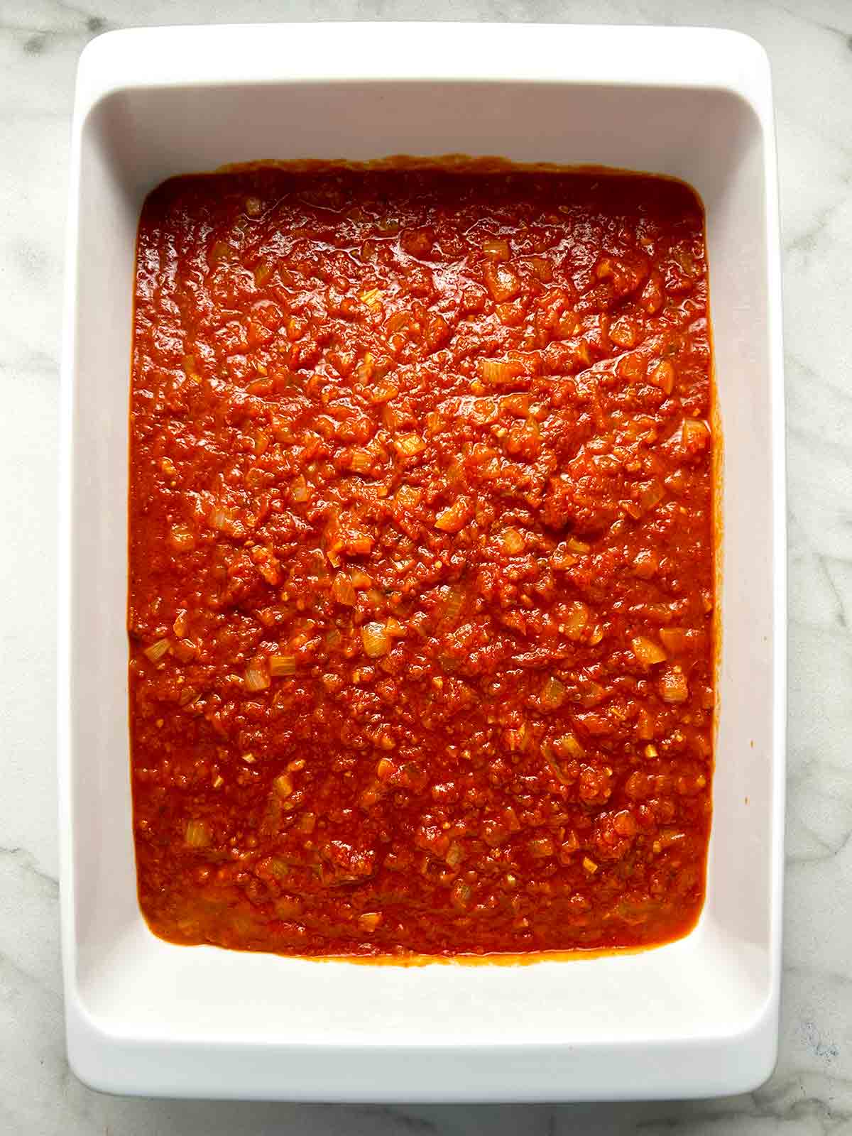 marinara sauce spread into baking dish.