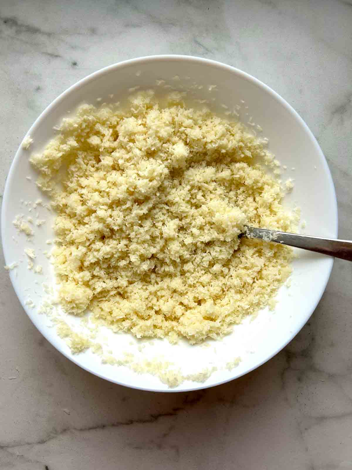 breadcrumbs mixed with milk in white bowl.