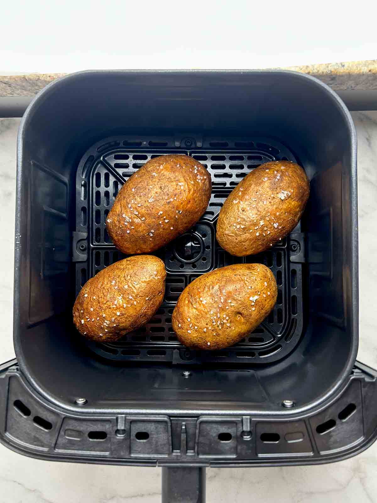 potatoes after being air fried; skin is slightly wrinkled and crisp.