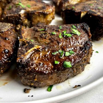close up of baked lamb loin chop on plate.