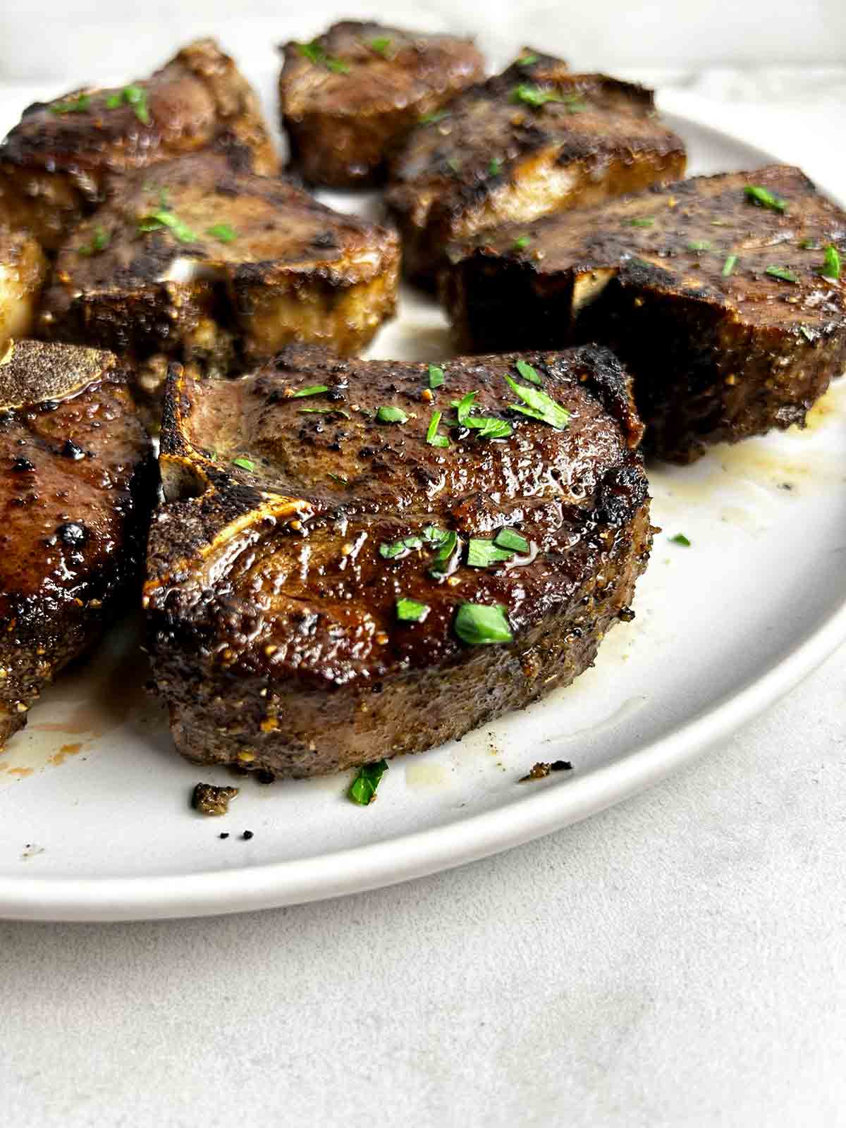close up of baked lamb loin chop on plate.