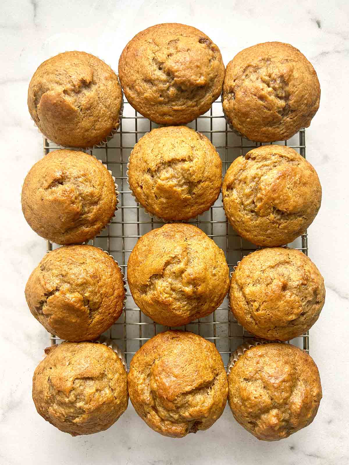 banana muffins resting on wire rack.