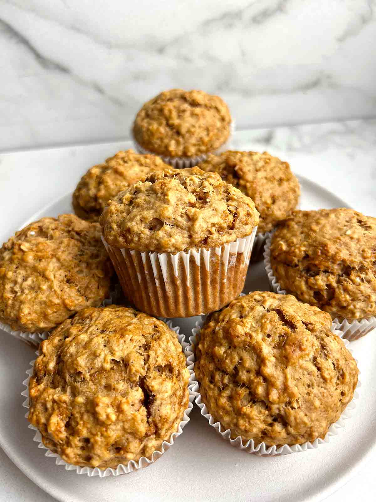 oatmeal applesauce muffins stacked onto plate.