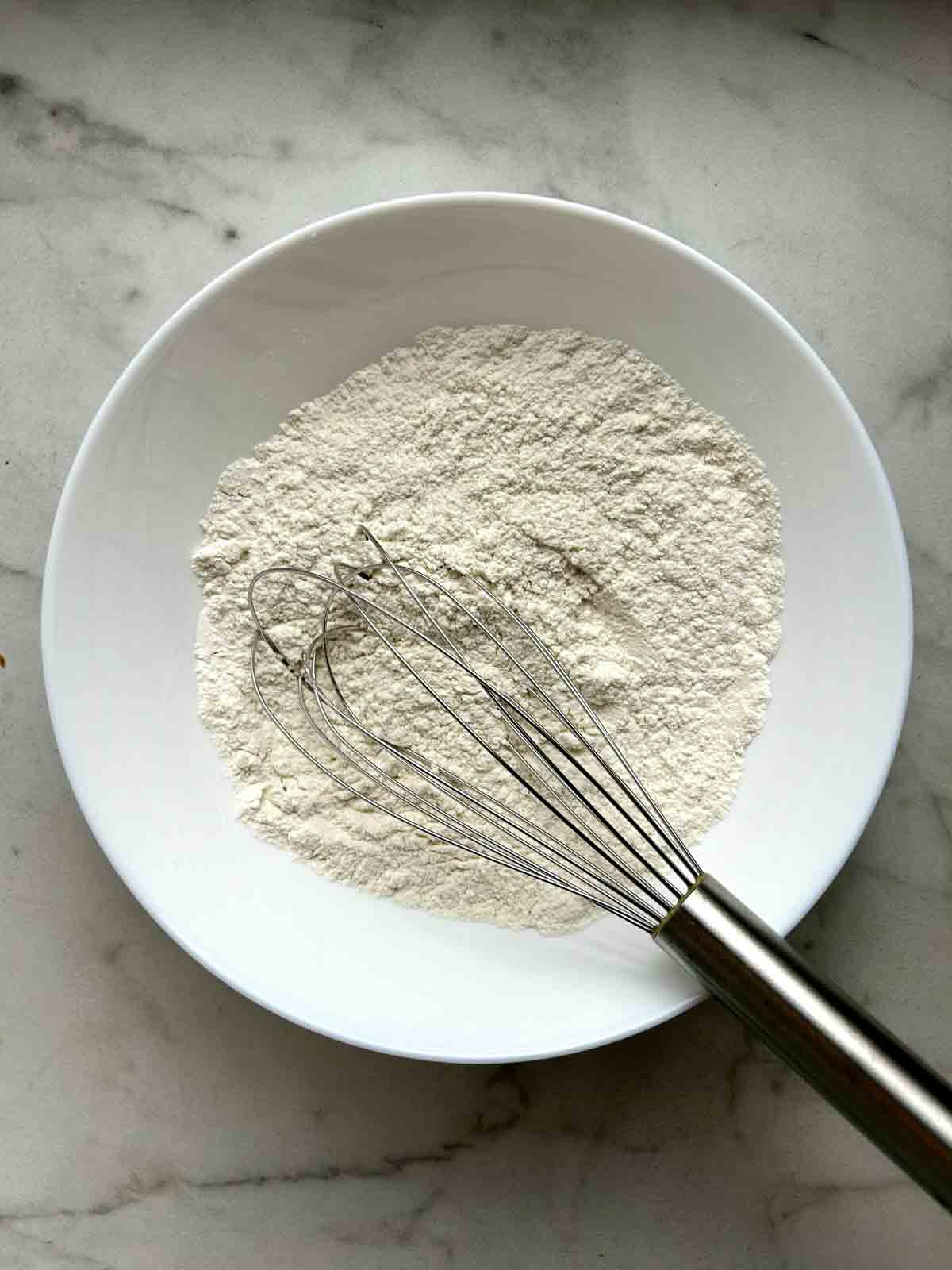 flour mixture whisked in white bowl.