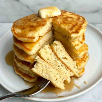 stack of pancakes with section cut through all of them to show the fluffy inside.