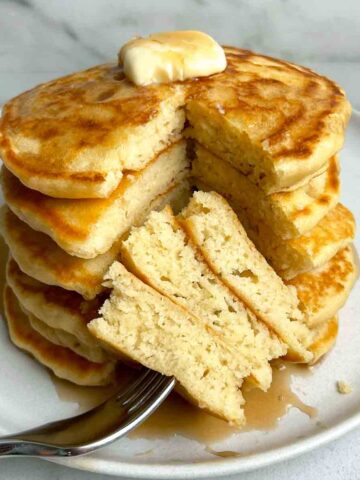 stack of pancakes with section cut through all of them to show the fluffy inside.