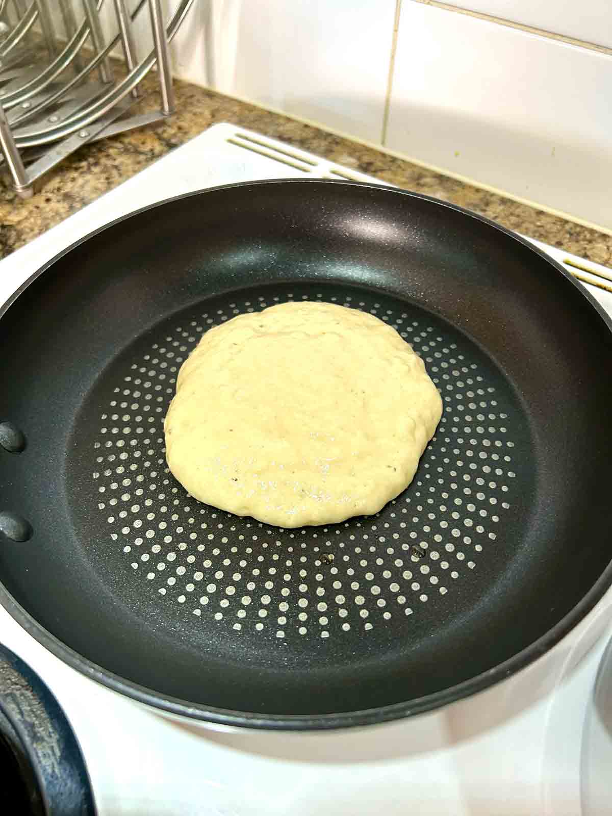 pancake batter scooped into skillet.