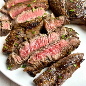 close up of medium-rare steak cut into slices.