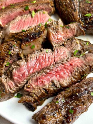 close up of medium-rare steak cut into slices.