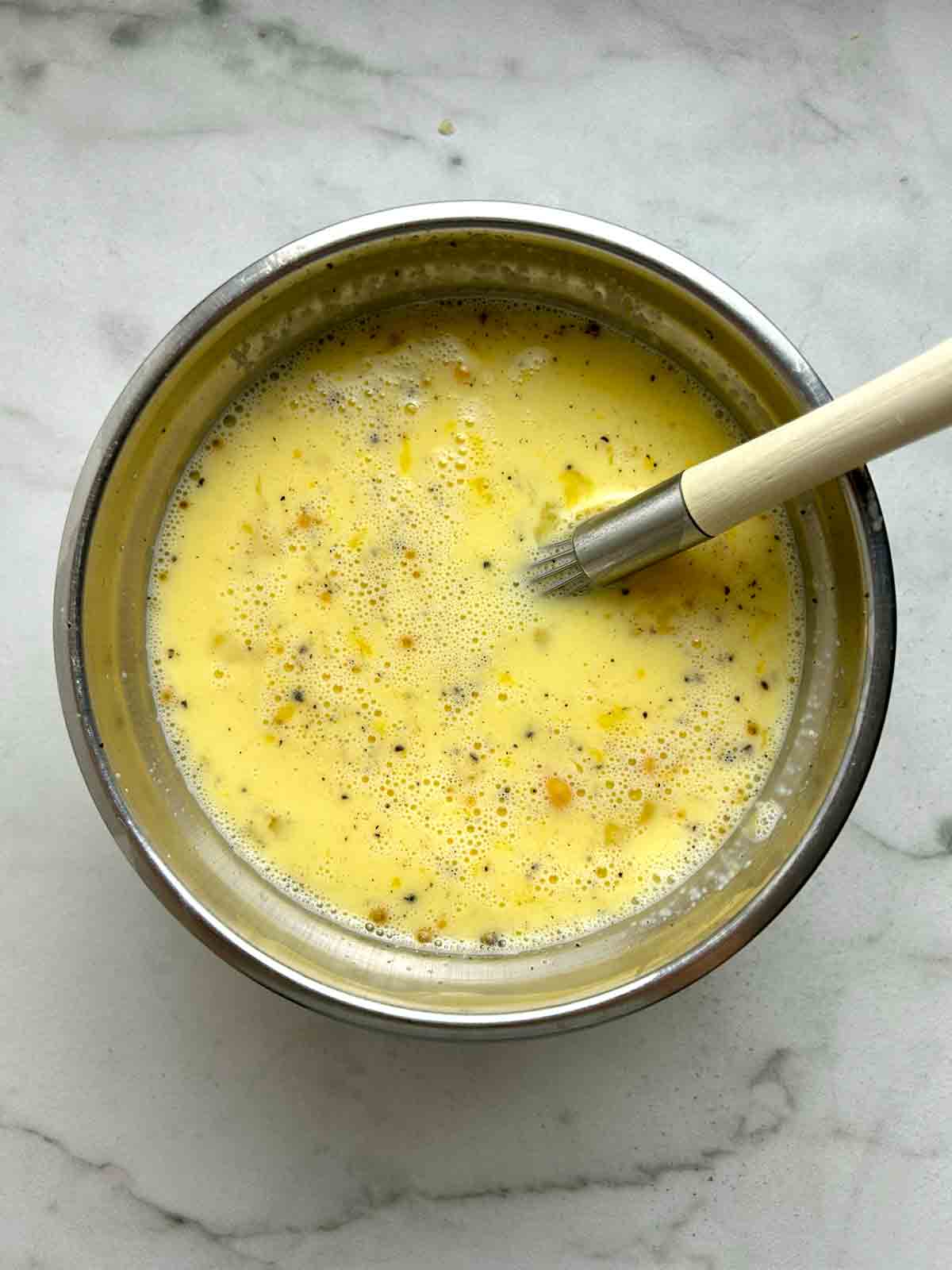 egg and milk mixture whisked in bowl.