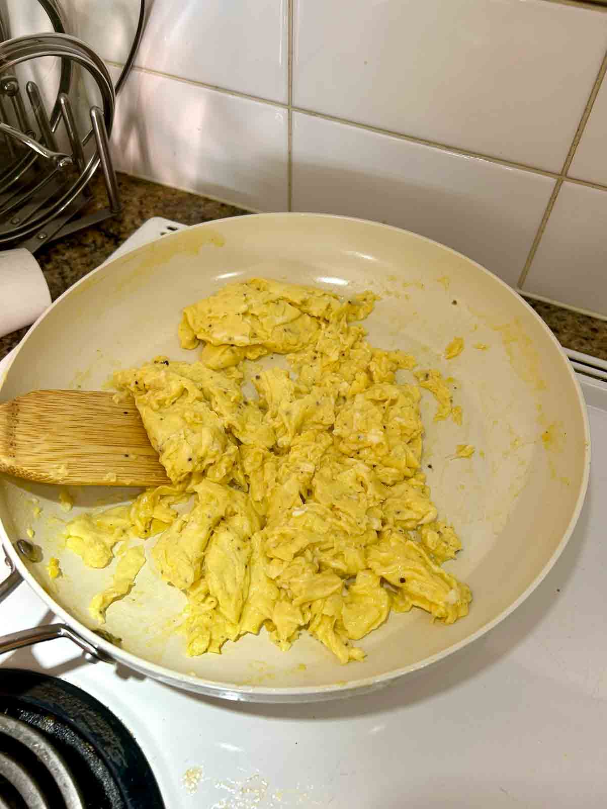 scrambled eggs in large white skillet.