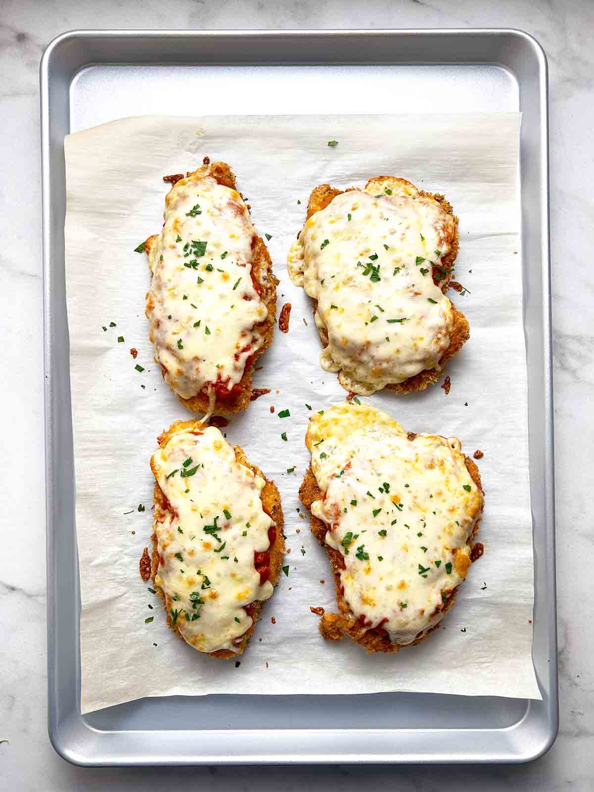 chicken parmesan in baking sheet after being baked.