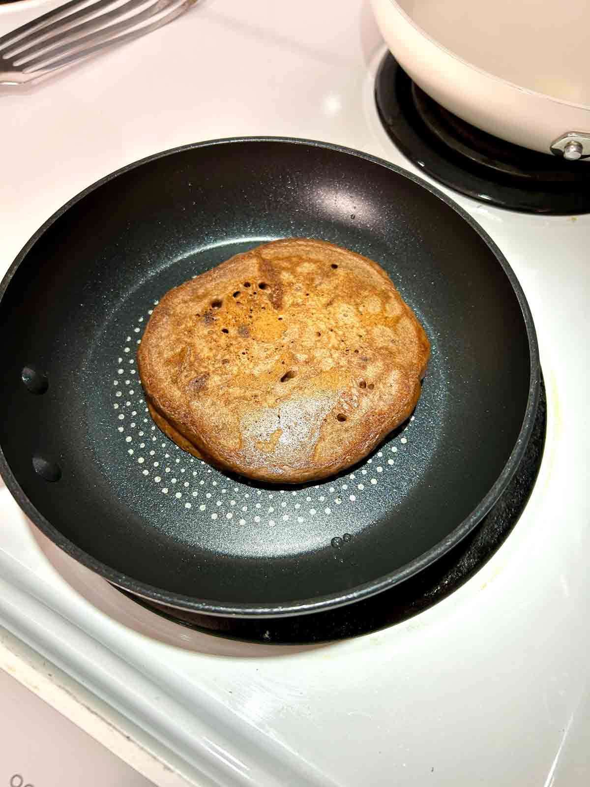pancake flipped in skillet to show cooked side.