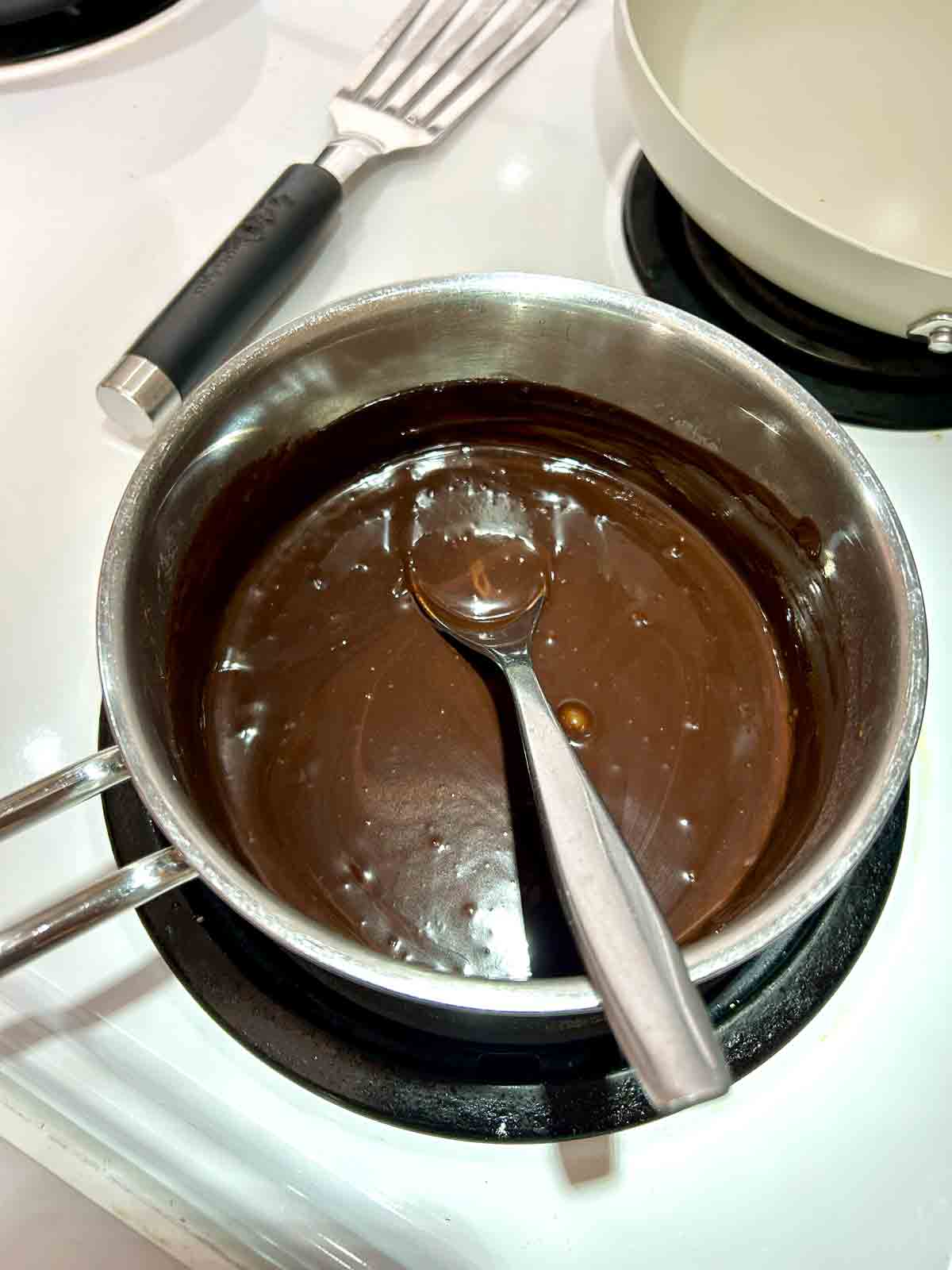 chocolate sauce being melted in saucepan.