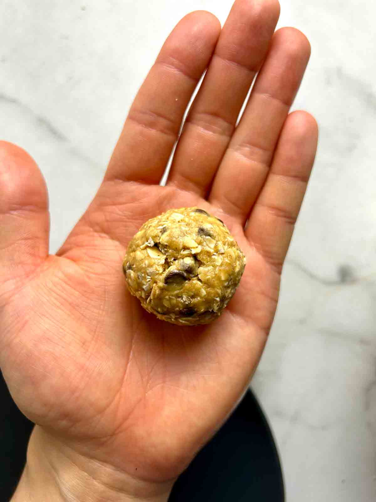 protein ball sitting in palm of hand.